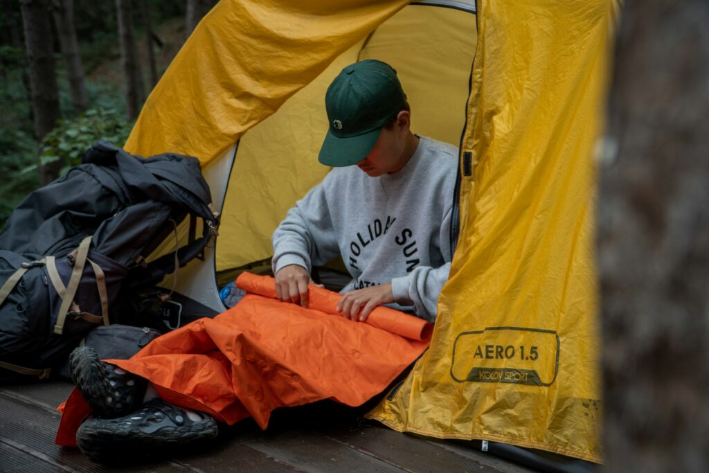 Kampeerder met een lichtgewicht opblaasbare slaapmat in een tent.